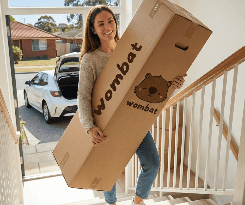 Woman easily carrying compressed Wombat sofa box